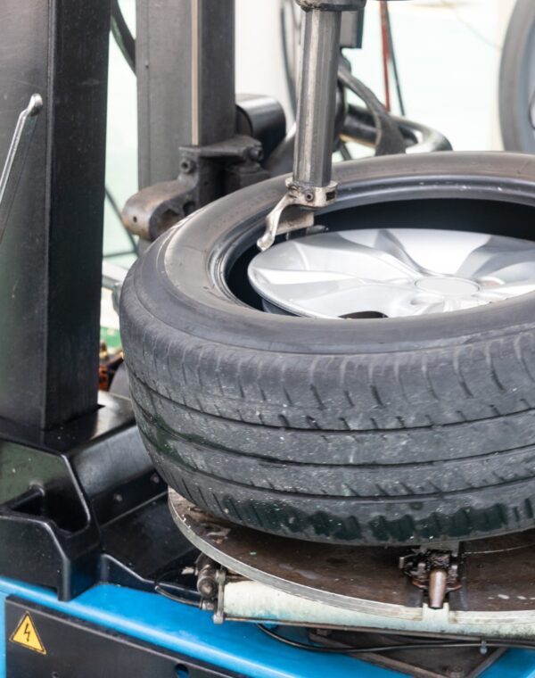 Series of worker removing tire from rim with tire removal machinery equipment